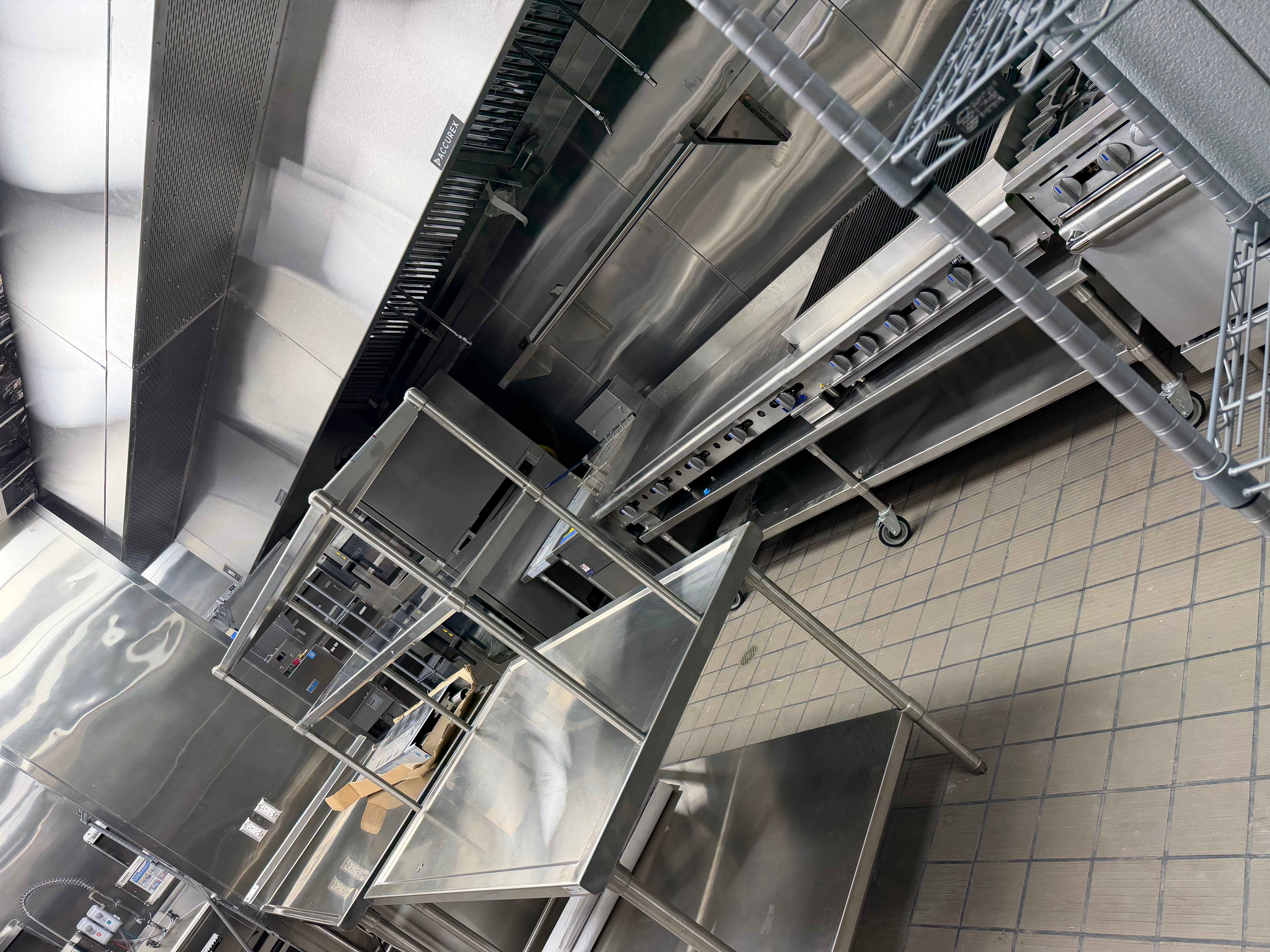 Commercial kitchen with professional-grade stainless steel equipment and exhaust hoods